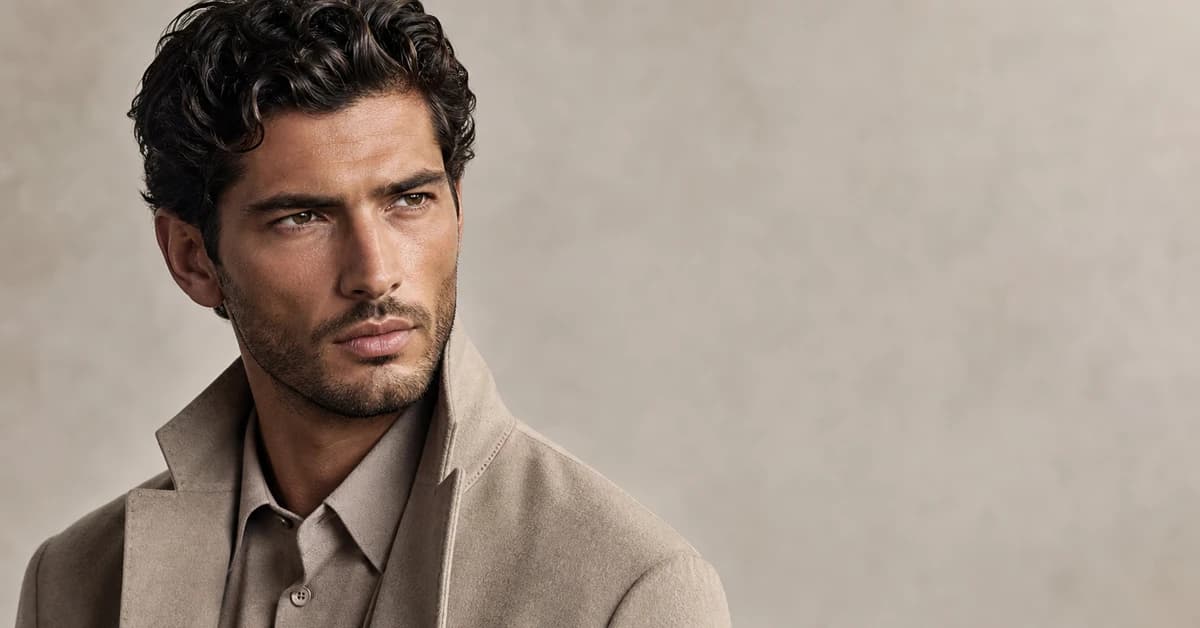 A man with warm undertones wearing a flattering olive overshirt and navy crew neck with a colour drape held to his face, by ToneLala