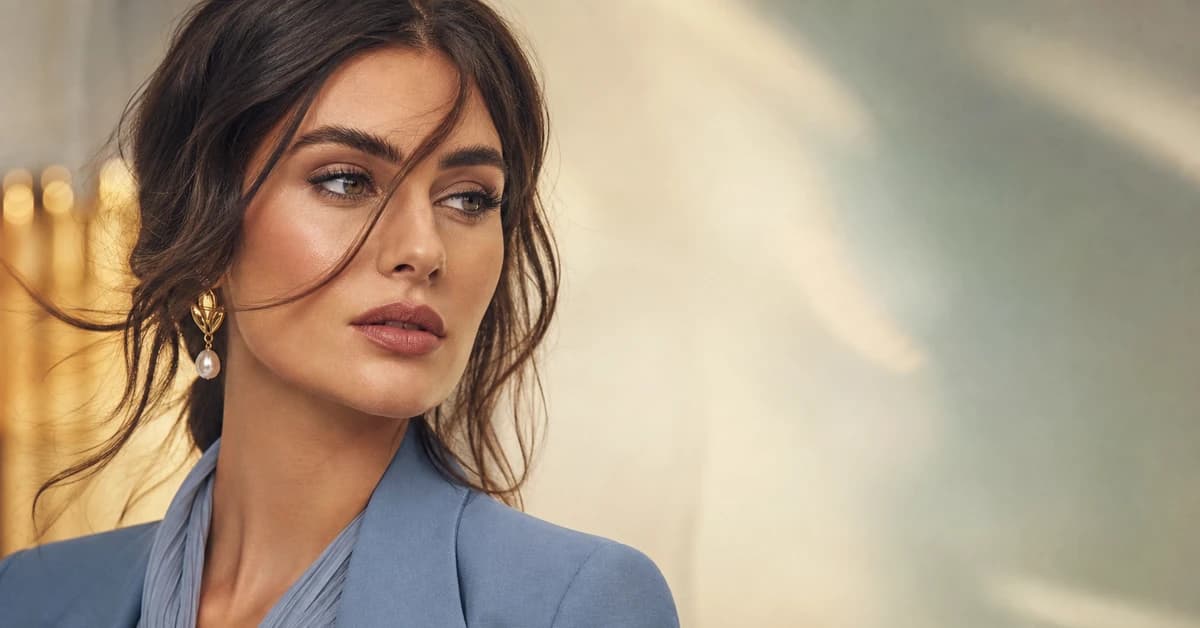 A colour-cohesive capsule wardrobe on a rail — camel, ivory, navy and soft blue pieces that all mix together, by ToneLala
