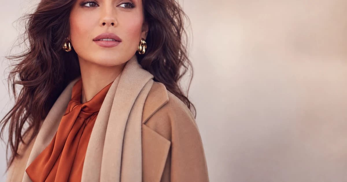 A Soft Autumn outfit — a camel coat over a soft coral knit with warm beige trousers and gold jewellery, by ToneLala