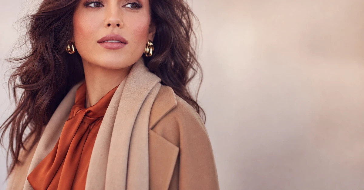 A Soft Autumn outfit — a camel coat over a soft coral knit with warm beige trousers and gold jewellery, by ToneLala