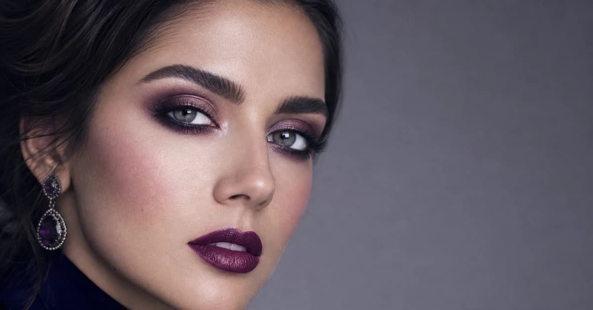 A woman wearing True Winter makeup — a cool blue-red lip, cool rose blush and charcoal-and-plum eye, by ToneLala